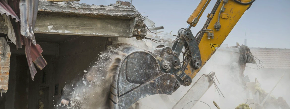 Koparka wyburzająca budynek – rozbiórki obiektów, kruszenie betonu i prace wyburzeniowe ciężkim sprzętem